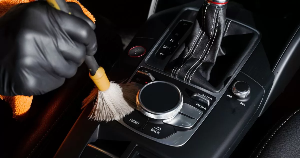 interior detailing a car's gearbox and dashboard with detailing brush
